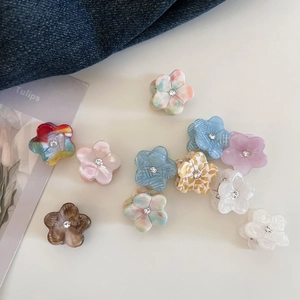 Detailed close-up of mini floral acetate hair clips with central rhinestones and diverse colors