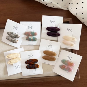 Detailed macro view of vintage oval acetate hair clips in various marble and solid patterns