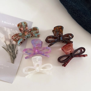 Detailed macro view of acetate bow hair clips with elegant marble patterns for styling