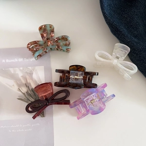 Detailed view of acetic acid bow hair clips in various marble patterns and colors