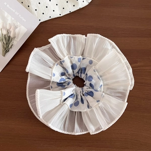 Detail of blue polka dot lace hair scrunchie made of light white tulle fabric