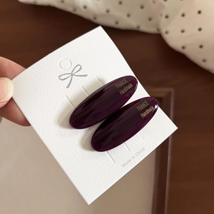 Detail of dark purple oval acetate hair clips with gold France Handmade lettering