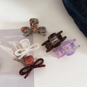 Detailed set of 5 acetate hair claws featuring marble patterns and bow tie designs