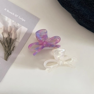 Detailed macro shot of acetate bow hair clips in marble purple and pearl white colors