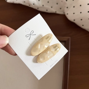 Detail of cream marble pattern acetate hair clips on a white display card