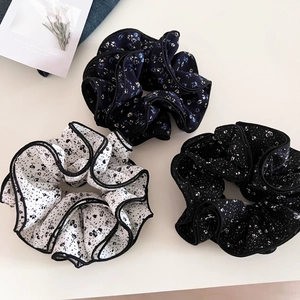 Three floral chiffon scrunchies in white, navy, and black with ruffled wood ear edges