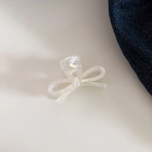 Detailed top view of a pearlescent white acetic acid bow hair claw clip for elegant styling
