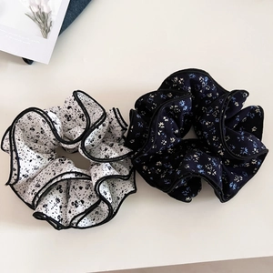 Detailed close-up of floral chiffon scrunchies with elegant ruffled edges and black trim