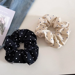 Détail de chouchous à pois noirs et beiges avec des étiquettes textiles élégantes