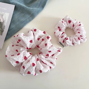 Detail view of sweet strawberry print hair scrunchies with pleated fabric texture