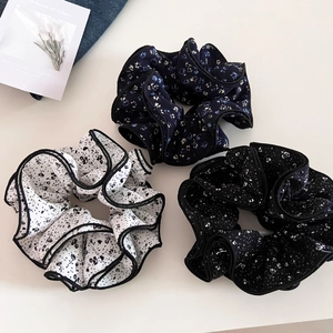 Detailed view of three vintage floral scrunchies with elegant black ruffled edges
