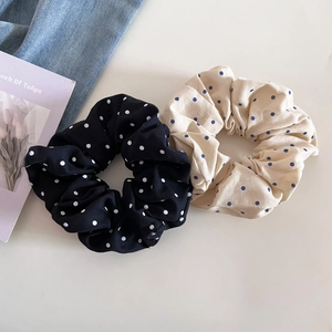Lot de chouchous à pois noirs et crème sur denim avec une carte de tulipes