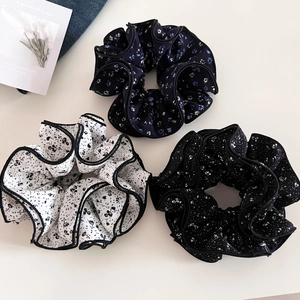 Set of three vintage floral ruffle scrunchies with black stitched edges on white background