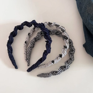 Detailed view of three fabric headbands featuring stripes, polka dots, and houndstooth patterns