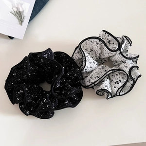 Detailed view of layered floral scrunchies with elegant ruffled edges and black piping