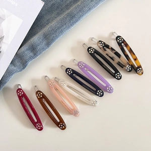Detail view of oval acetate hair clips in multiple colors with rhinestone accents
