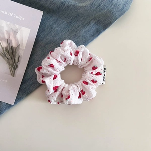 Sweet strawberry print ruffled scrunchie on blue denim and tulip card background