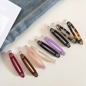 Detail of colorful acetate hair clips with rhinestones and Creation France lettering