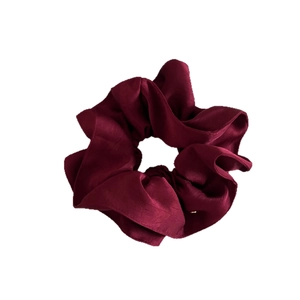 Chouchou élégant en satin rouge vin avec texture soyeuse et plis sur fond blanc pur