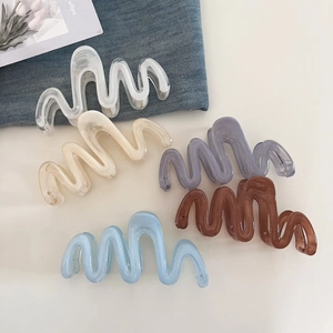 Detailed view of large wavy acrylic claw clips in five pastel colors for stylish hair styling