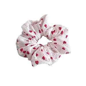 White puffy scrunchie with sweet red strawberry patterns and pleated seersucker texture