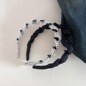 Detailed view of polka dot fabric headbands with non-slip teeth for secure retro styling