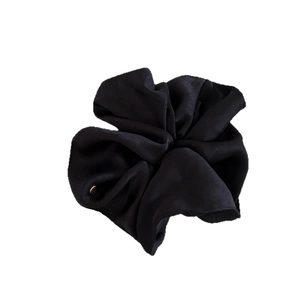 Elegant black satin hair scrunchie with a small golden brand logo tag for women