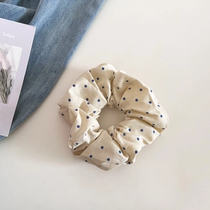 Détail d'un chouchou vintage beige à pois bleus en tissu de coton et lin texturé