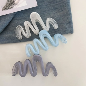 Detailed view of large wavy hair claws in marble white, light blue, and grey colors