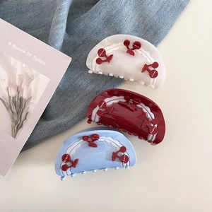 Detail view of sweet cherry hair claws set in white, red and blue with wavy patterns
