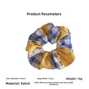 Detailed view of yellow and blue plaid scrunchie with 13.5cm diameter fabric dimensions