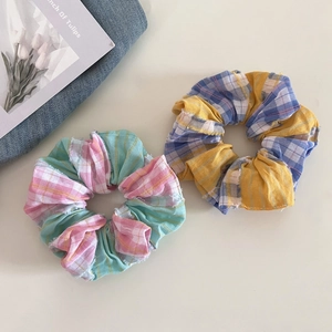 Detail of sweet plaid fabric scrunchies with pink, green, yellow and blue patchwork