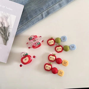 Détail de barrettes pomme rouge mignonnes avec perles colorées et smileys sur denim