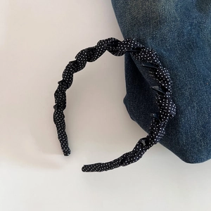 Detailed view of polka dot headband with built-in small clips for hair styling