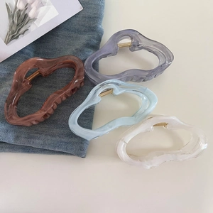Macro detail of large jelly colored wavy cloud hair clips in multiple pastel shades