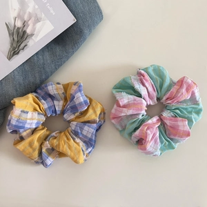 Close-up of checkered fabric hair scrunchies with frayed edges and cotton texture