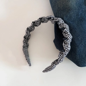 Detail shot of black and white checkered fabric headband with inner non-slip plastic teeth