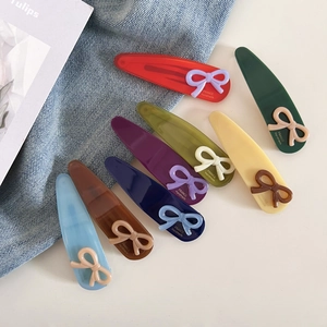 Vue à plat de pinces à cheveux colorées en acétate avec texte France Handmade sur denim