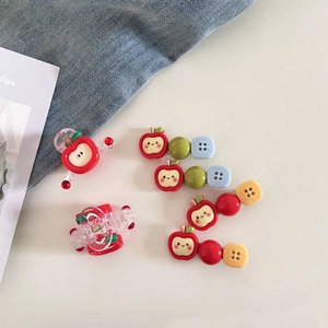 Détail de barrettes à cheveux mignonnes en forme de pomme et bouton en résine colorée
