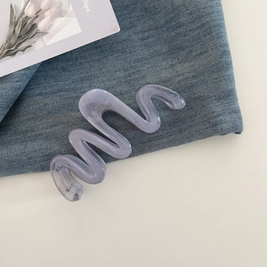 Detail of wavy translucent Morandi purple hair claw clip on denim background