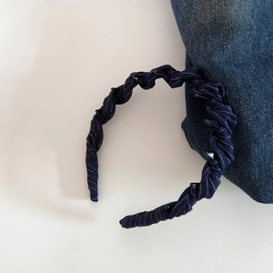 Detail of navy blue striped fabric headband with non-slip inner teeth and retro texture
