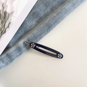 Detail of dark blue acetate hair clip with rhinestones and gold Creation France logo