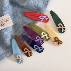 Barrettes à cheveux chic en acétate avec nœuds, couleurs assorties sur fond denim