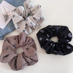 Three-piece set of floral rose print hair scrunchies in beige, black, and purple