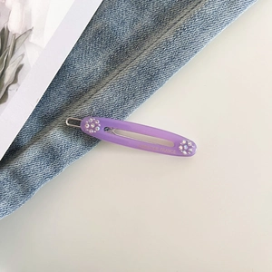 Detail of oval purple acetate hair clip with rhinestones and Creation France engraving