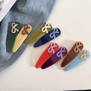 Détail de pinces à cheveux noeud papillon en huit couleurs sur fond en jean bleu clair