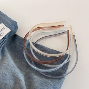 Detail view of colorful jelly hairbands with non-slip teeth on blue denim background