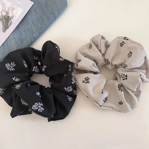Detail of vintage rose print scrunchies in black and beige soft fabric texture