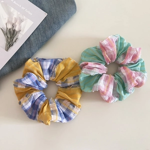 Close-up of vintage plaid scrunchies with yellow, blue, and mint green checkered patterns