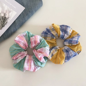 Two-pack plaid scrunchies with pink and green checkered pattern and raw edge finish